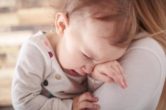 Bebé llorando en el ombro de su madre