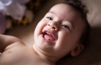 Bebé sonriente acostado en la cama