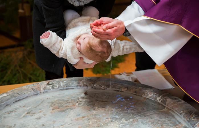Sacerdote bautizando niña