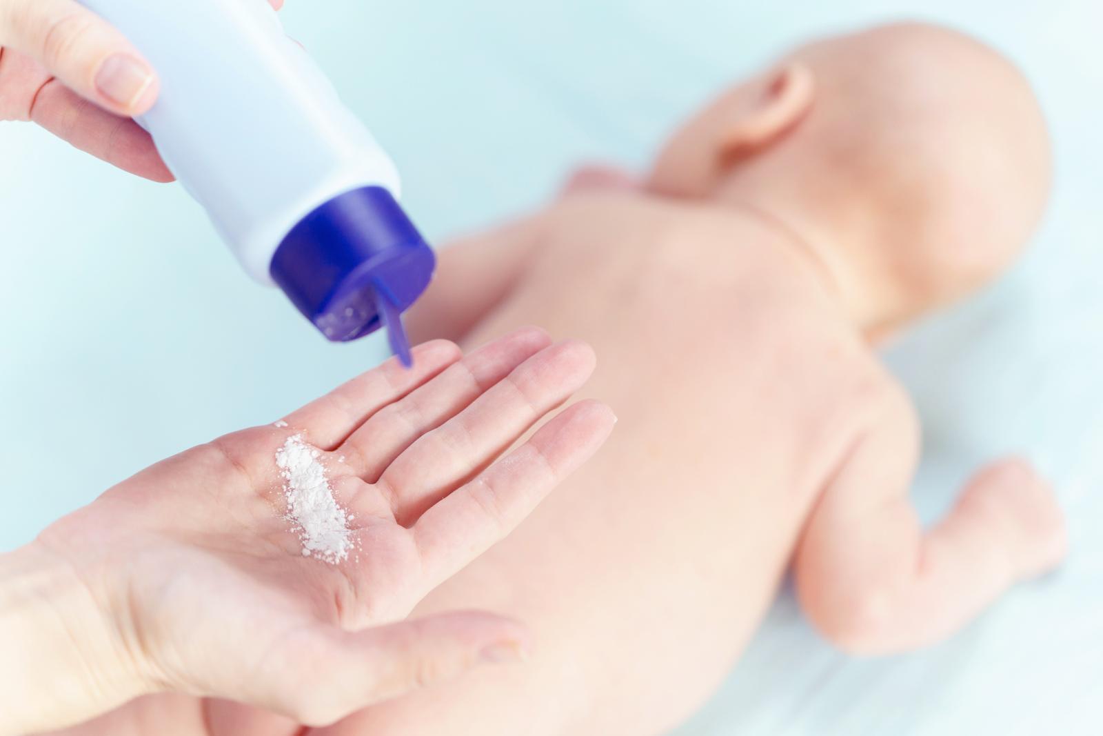 Madre aplicando talco infantil al bebé