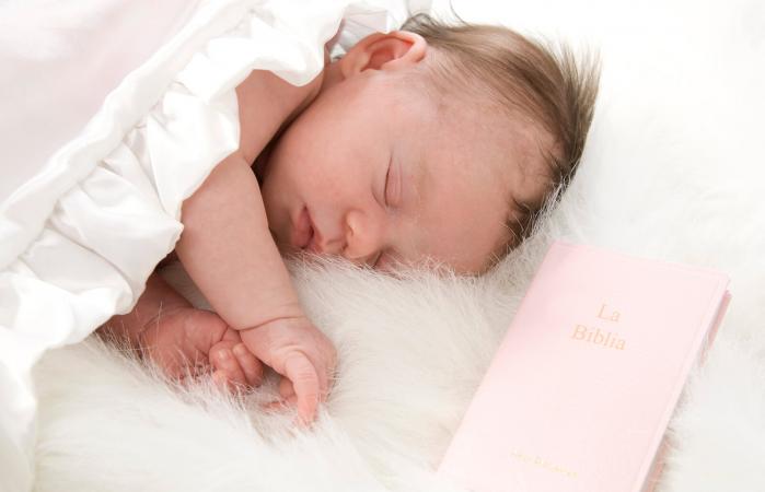 Bebé recién nacido durmiendo con la Biblia