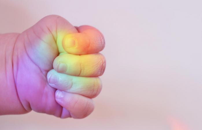 Mano de bebé con los colores del arco iris