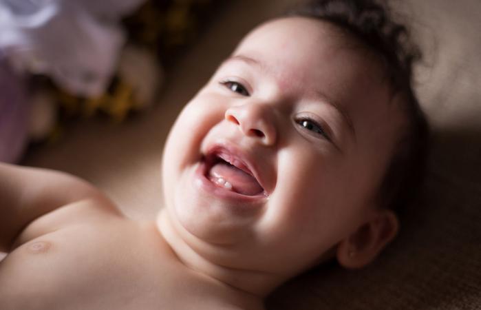 Bebé sonriente acostado en la cama