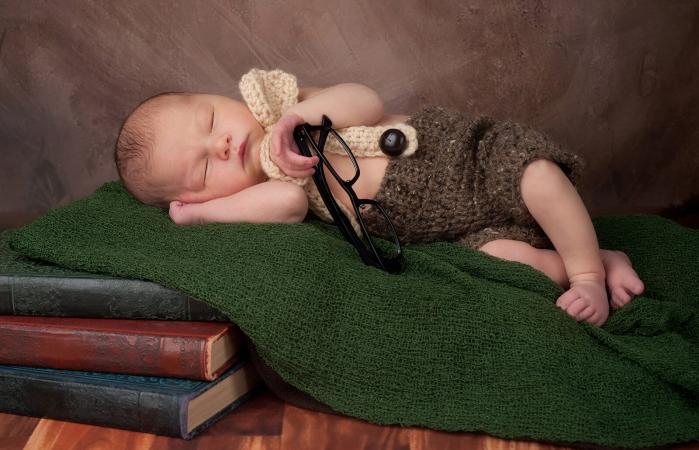 Bebé durmiendo sobre libros