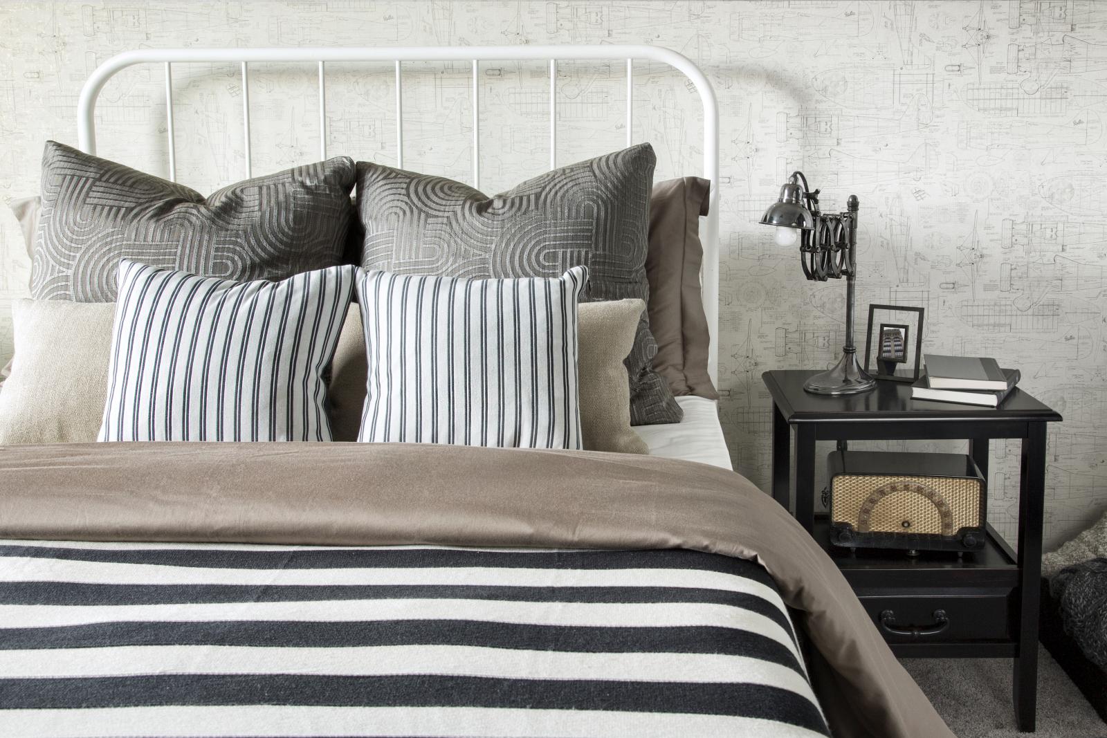 Striped and patterned pillows and blanket on bed