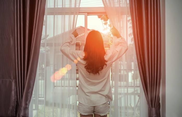 Woman Holding Curtains