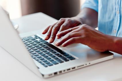 hands typing on laptop