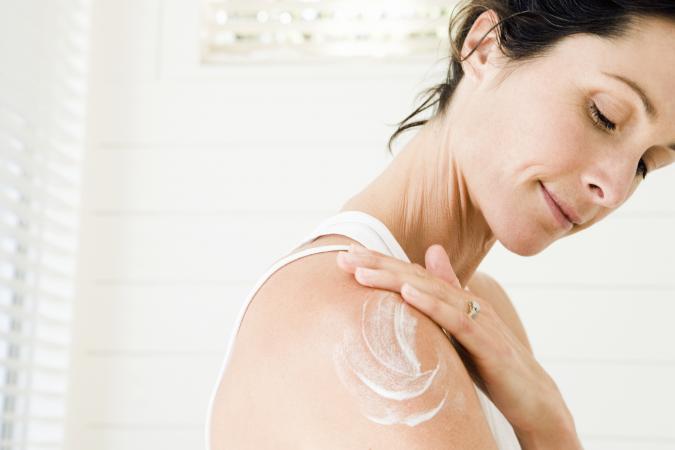 Woman applying moisturiser