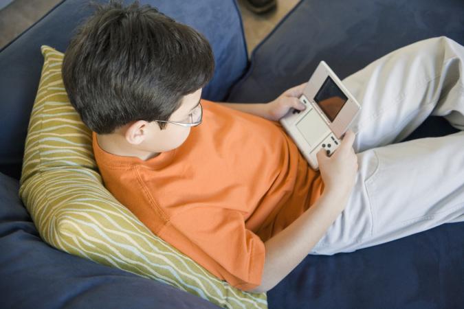 Boy playing handheld video game