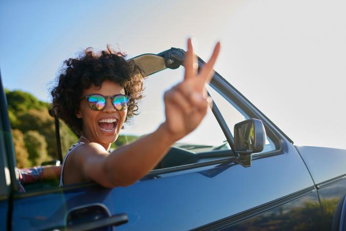 Woman in car flashing peace sign