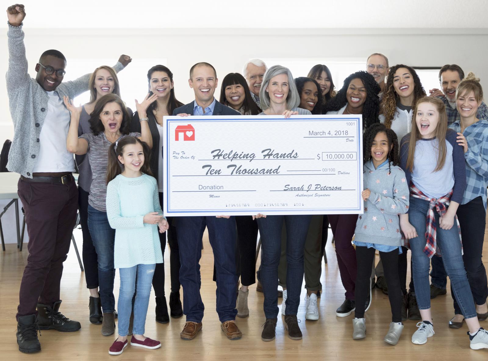 Enthusiastic community with large donation check
