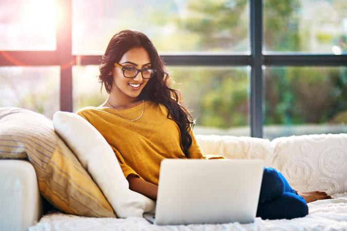 Woman relaxing at home using laptop