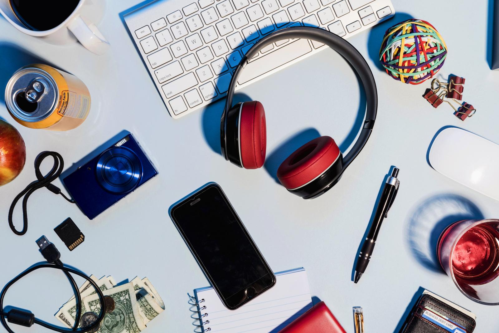 Headphones, smart phone, digital camera and office supplies on desk