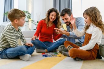 Parents playing board game with their children