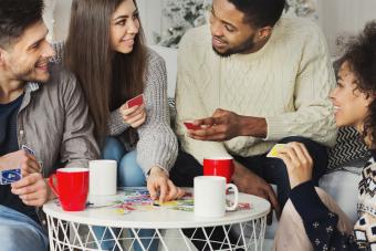 Happy friends playing game of cards UNO