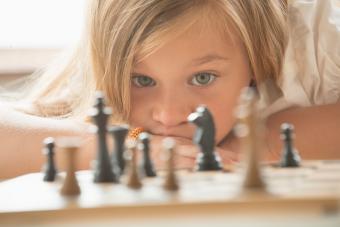 girl examining chess game board