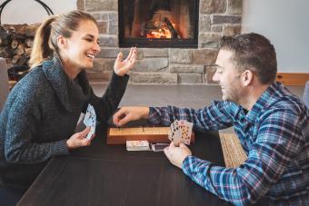 Couple playing cribbage in a warm home with fireplace