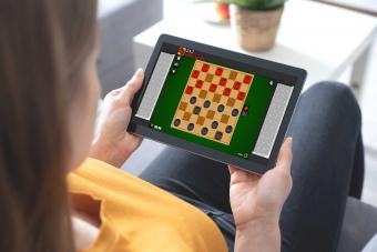 woman on tablet computer playing online checkers game