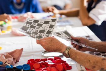 senior mans hands passing out number cards for a game of bingo