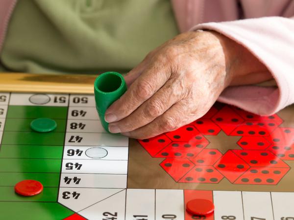 Woman playing Parcheesi boardgame