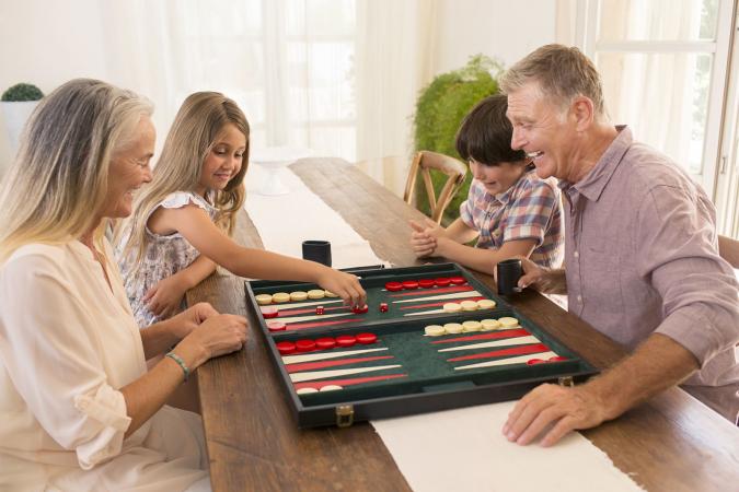 Grandparents and grandchildren playing backgammon