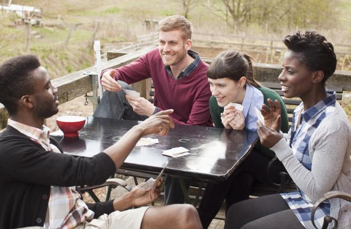 Four friends playing Apples to Apples card game