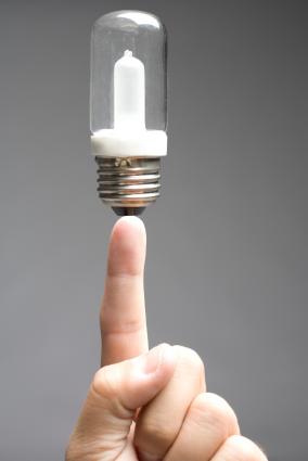 Finger holding up lightbulb