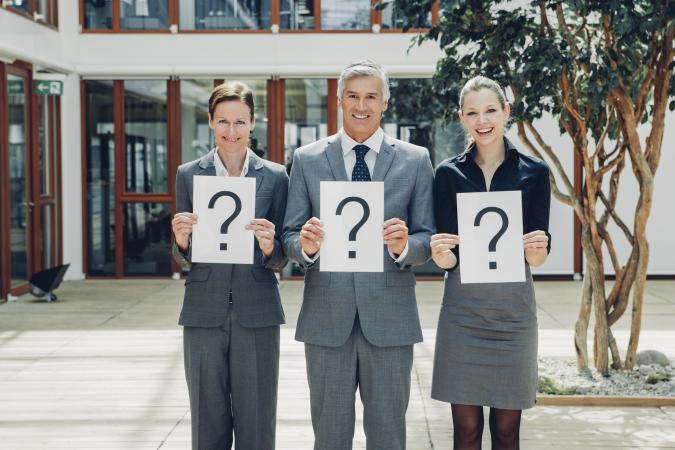 Business people with question mark on placards