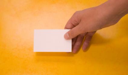 Hand holding a blank example of a business card