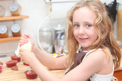 Girl decorating Christmas cupcakes