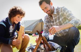 Father and son building campfire