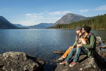 couple and their dog sit and enjoy Lake Wenatchee.