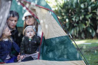 family stuck in their tent during a rainy day