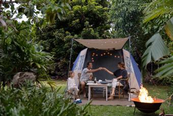 Parents cheers over a glass of red wine while camping