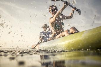 Couple rowing canoe on still lake