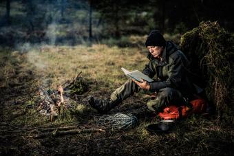 Man reading book in forest