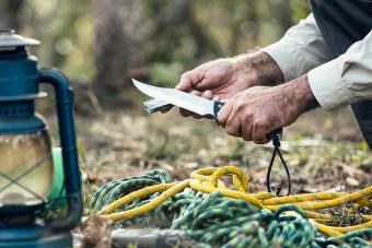 Man hands sharpening knife outdoors