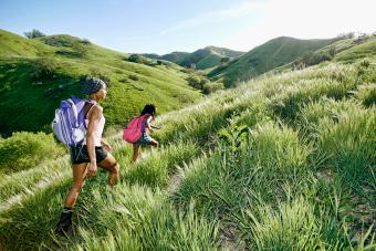 mother and daughter walking on rural hillside