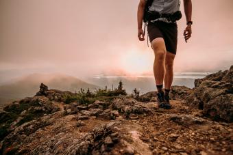 Hiker with cell phone walks along Appalachian Trail