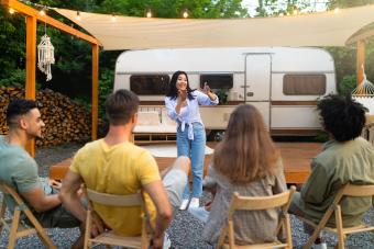 Group of cheerful young people enjoying charades outdoors