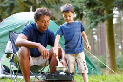 Father and son cooking breakfast on camping trip