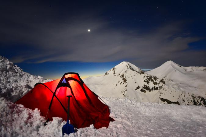 Red tent in snowy mountains