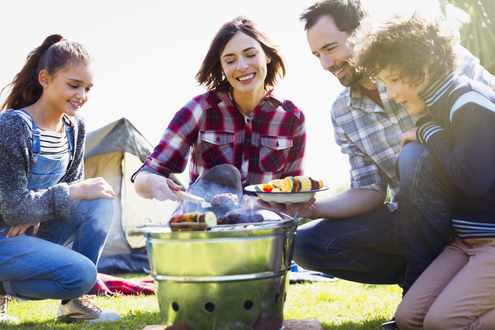 Family barbecuing at campsite grill