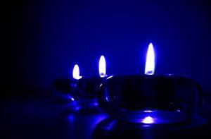 Three blue candle holders with candles