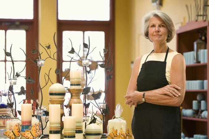 Shop owner standing in front of candle display
