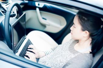 woman on laptop in car