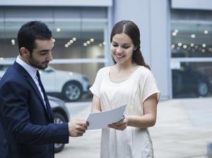 Woman looking at car dealer documents