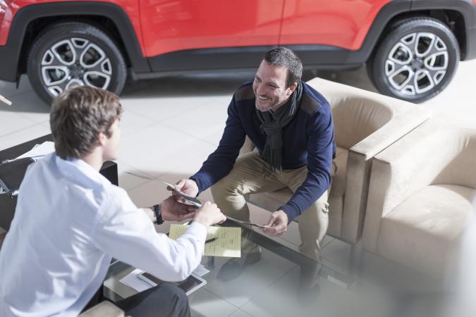 Man and car broker discussing options