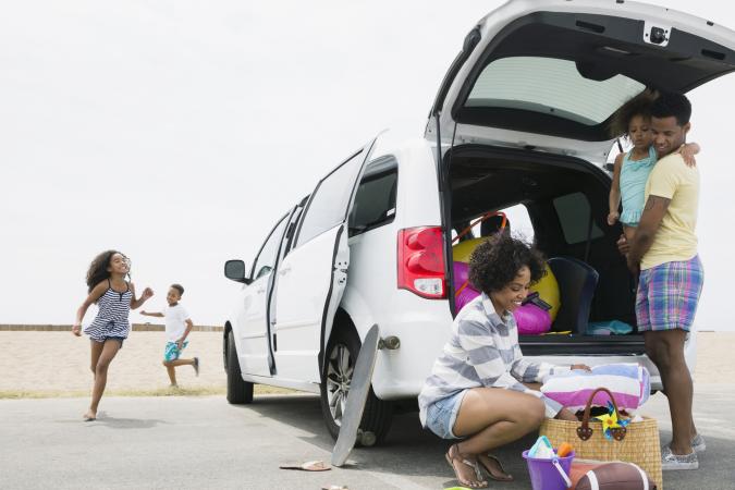 Family unloading van at beach