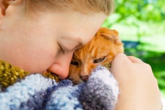 A girl holds her cat close before she has to be put to sleep